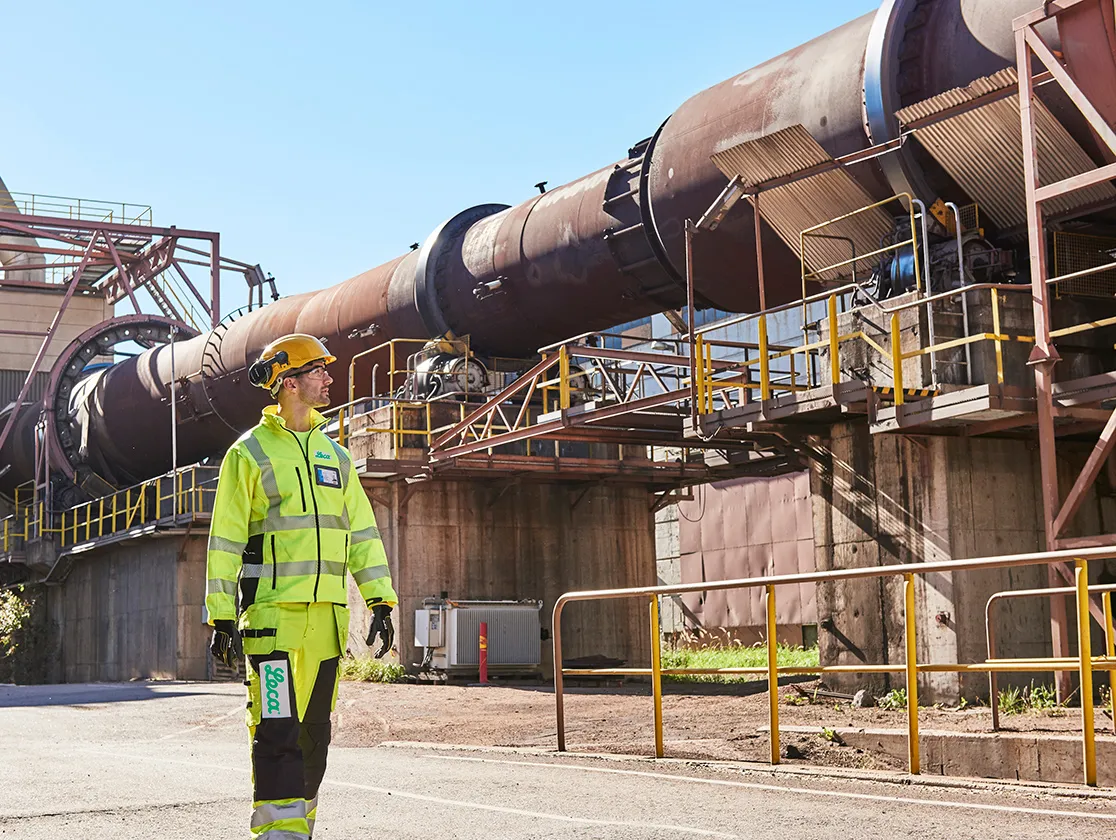 Ouvrier debout à côté d’un four rotatif dans l’usine Leca en Finlande