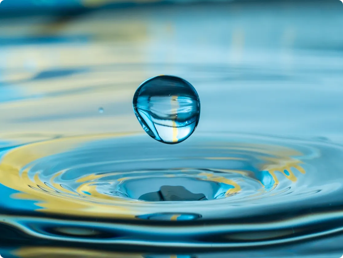 Goutte d’eau au dessus d’une surface d’eau formant des ondulations