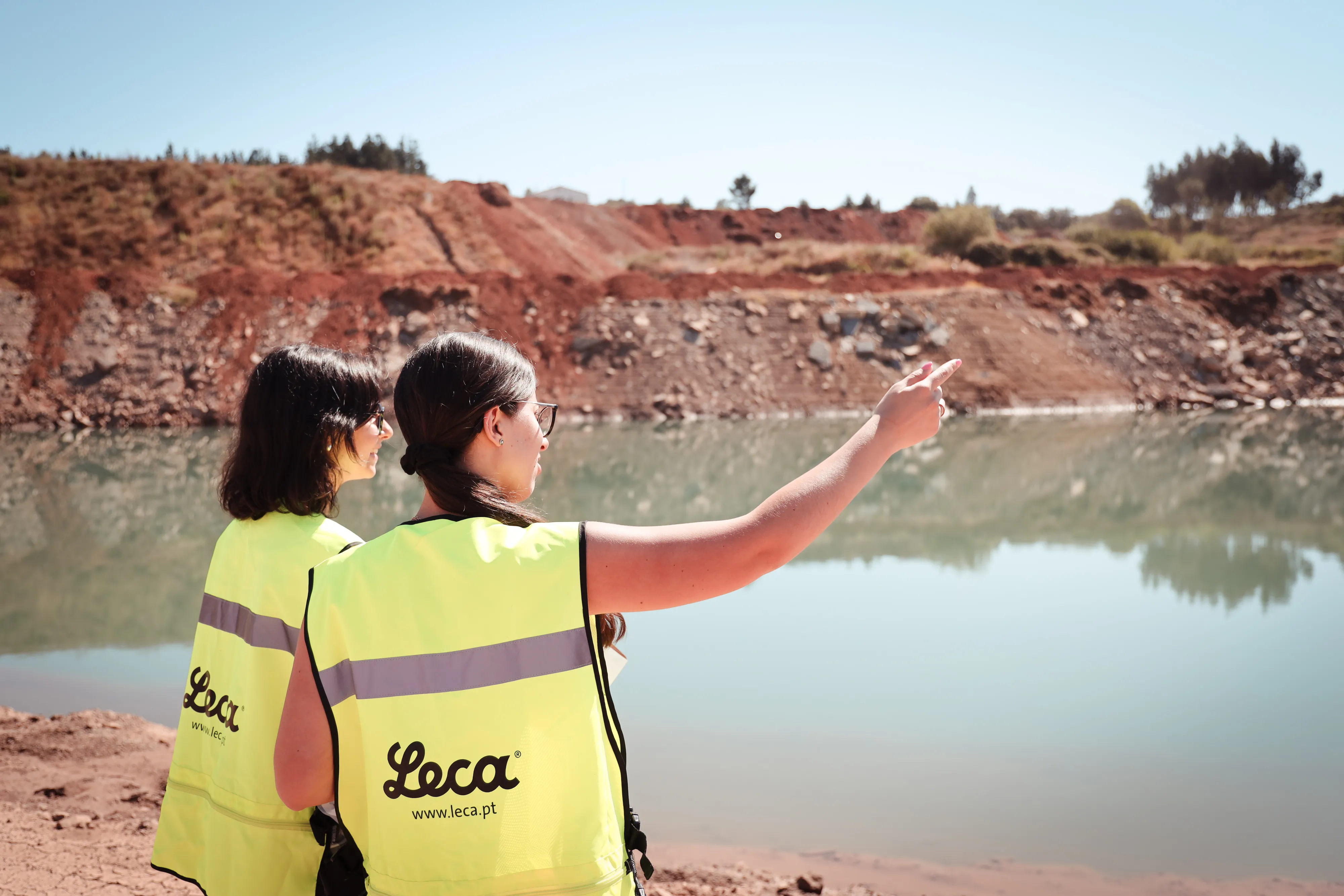 Two workers in high-visibility Leca vests overlooking a clay pit at Leca Portugal site