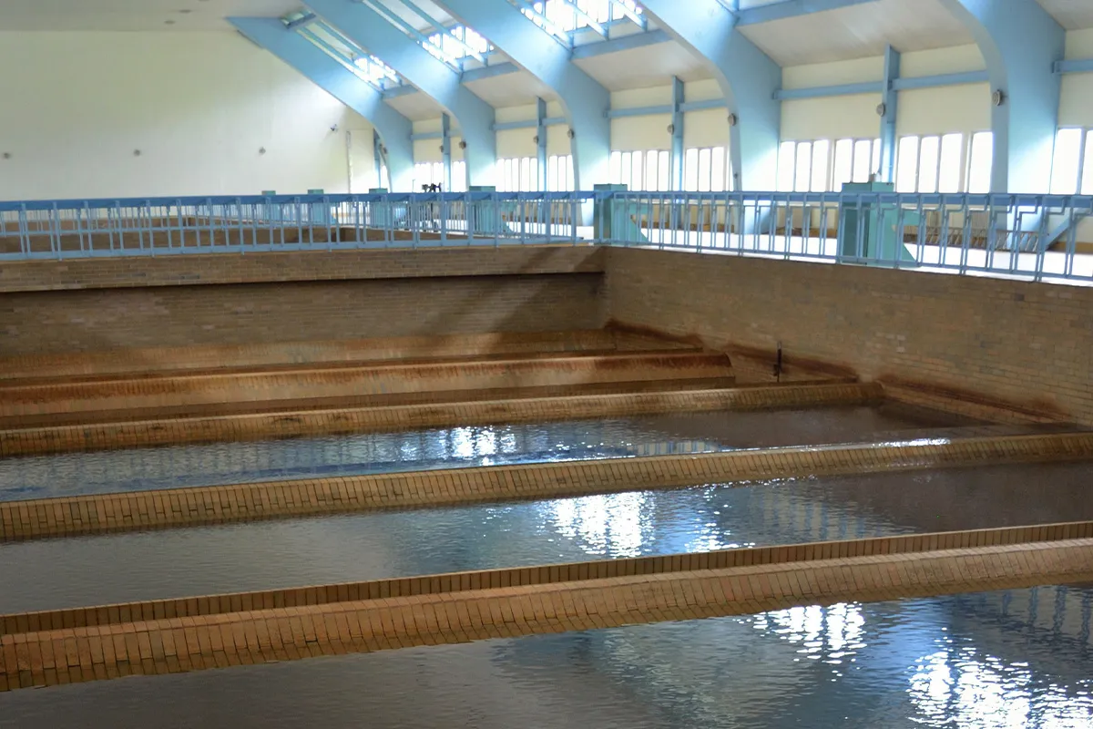 Intérieur de l’usine de traitement d’eau de Bedrichov montrant de grands bassins de filtrationremplis d’eau et des murs carrelés