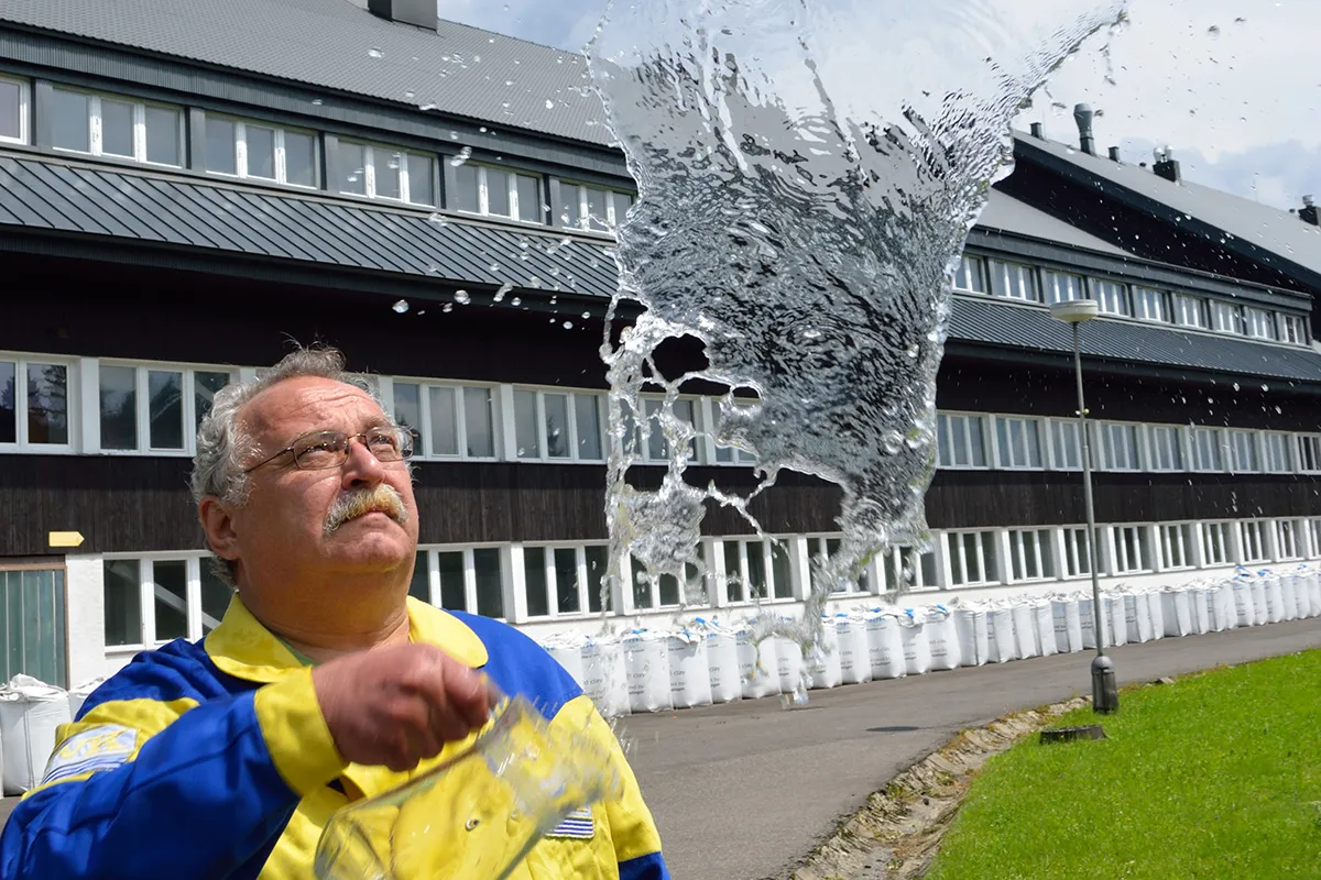 Ladislav Rainis, directeur régional de la North Bohemian Water Company, montrant la clarté del’eau en lançant de l’eau en l’air devant l’usine de Bedrichov, avec des sacs de Filtralite visibles à l’arrière-plan
