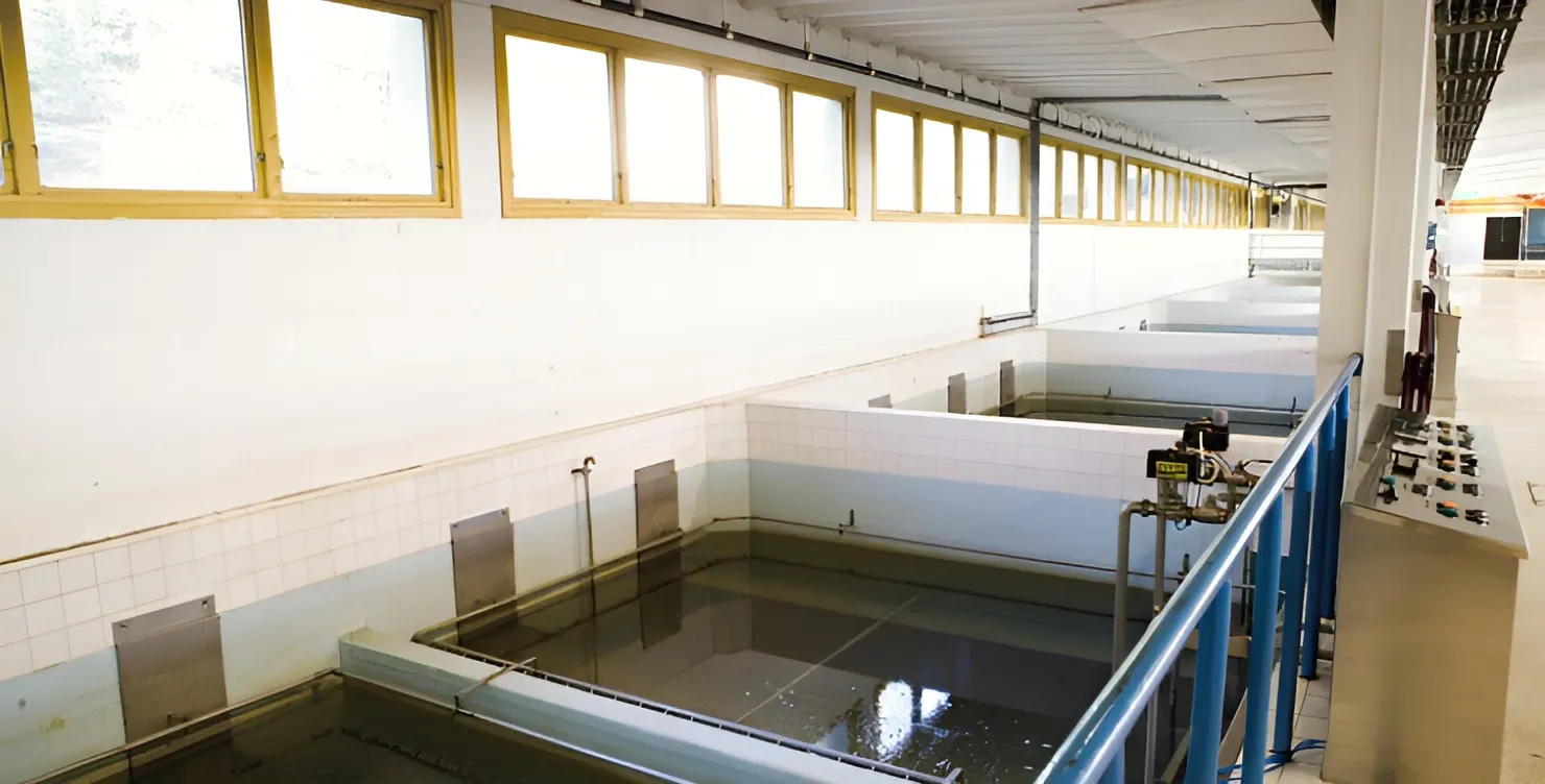 Vue intérieure de l’usine de traitement d’eau de Fredrikstad montrant des bassins de filtration avecdes murs carrelés et des panneaux de contrôle
