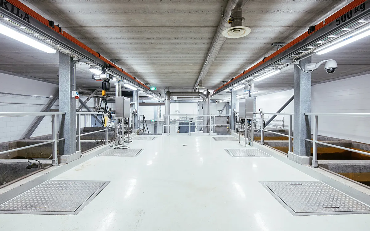 Vue intérieure de l’usine de traitement d’eau de Jäniksenlinna montrant une salle de filtrationpropre et bien éclairée, avec des tuyauteries en hauteur et des plateformes d’accès