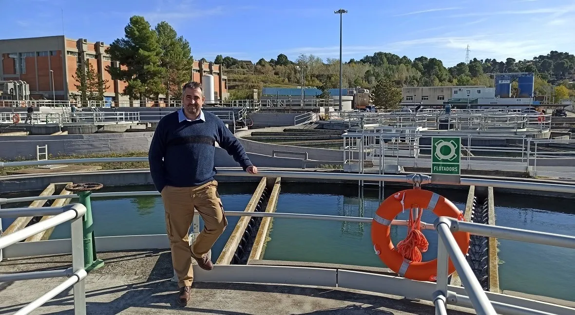 Santiago Gonzalez Avellana debout sur une plateforme à l’usine de traitement de Llobregat, avecdes bassins de filtration circulaires en arrière-plan