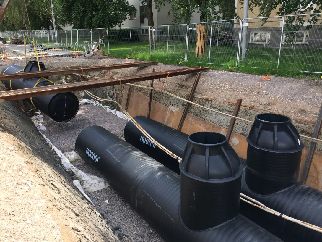 Installation d’un système de traitement des eaux pluviales souterrain, avec de grandes cassettes de filtration noires placées dans une tranchée préparée
