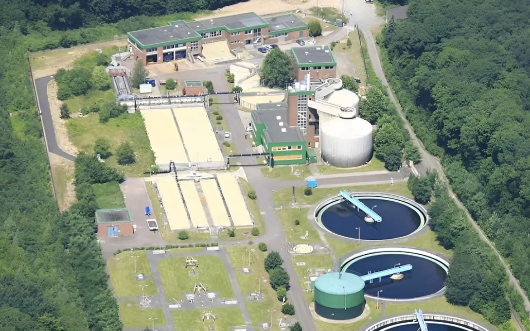 Vista aérea de la planta de tratamiento de aguas residuales de Rodenkirchen, rodeada de bosque