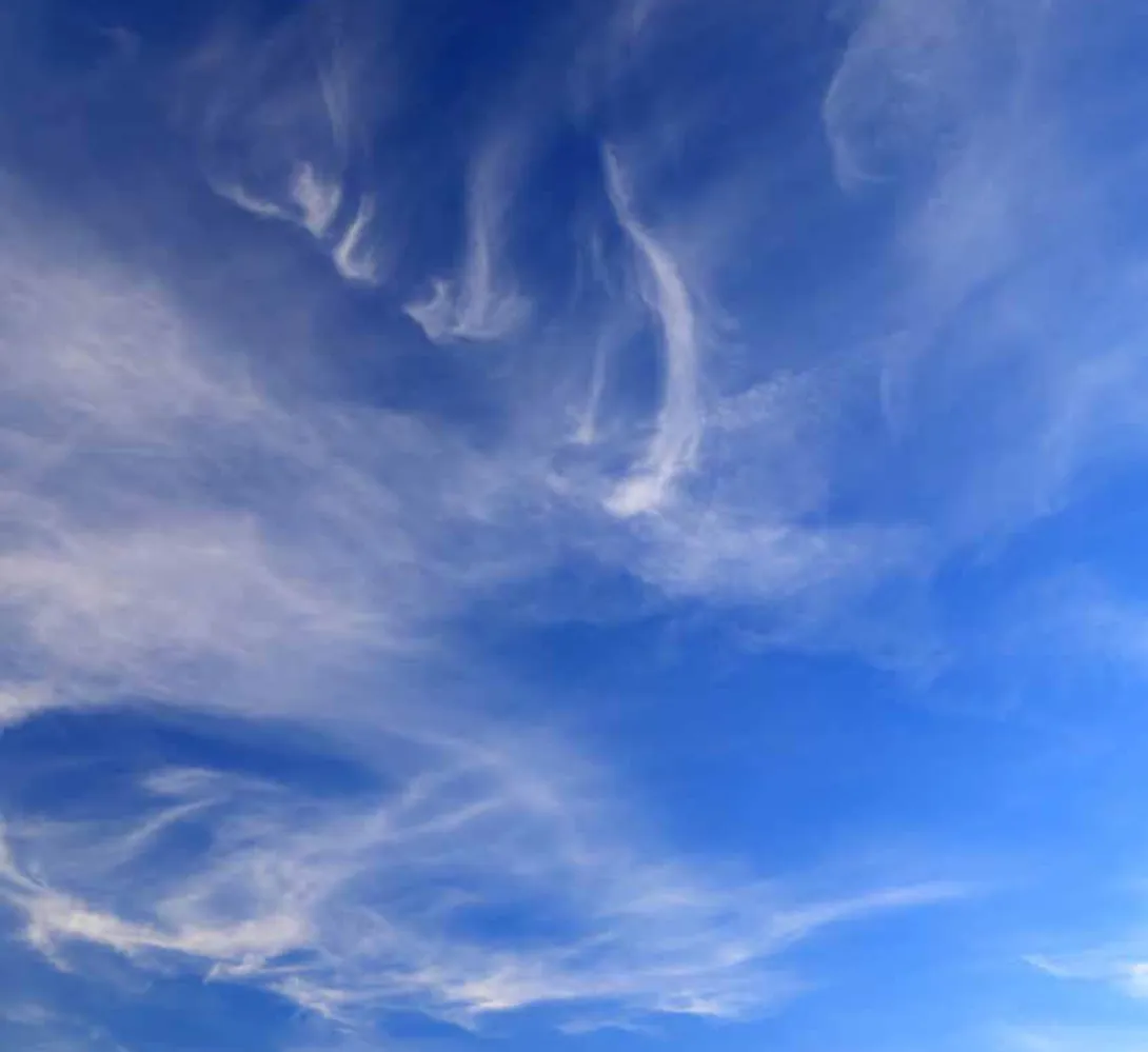 Wispy clouds scattered across a blue sky